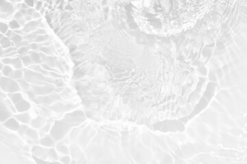 White water with ripples on the surface. Defocus blurred transparent white colored clear calm water surface texture with splashes and bubbles. Water waves with shining pattern texture background.