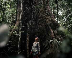 mulher ao lado de sumauma na floresta amazonica