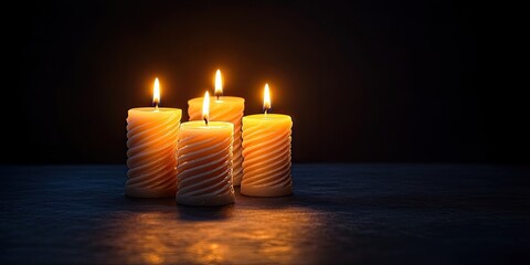 Warm candlelight flickers from four spiral candles in a dark setting highlighting serenity and reflection perfect for memorial services