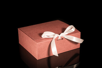 gift box decorated with a white bow on an isolated black background with a clipping path