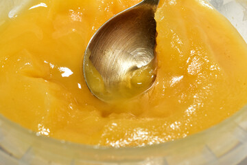 Linden flower honey and spoon in a bucket. Close-up.