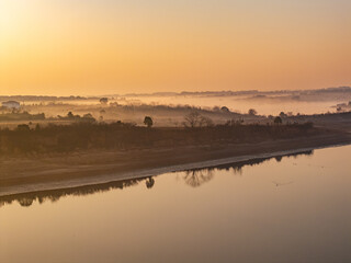 Naklejka premium Sunrise and fog in rural forest