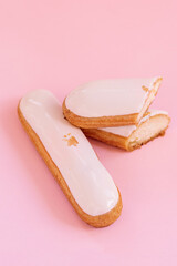 eclairs decorated with white cream and gold isolated on pink background