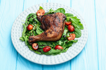 Grilled chicken legs with tomatoes and salad . Top view
