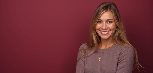 Obraz premium Happy blonde woman in sweater on dark red background