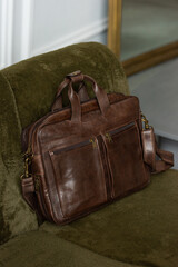 Brown leather briefcase on a luxury sofa, close up.
