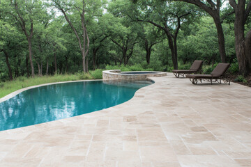 A pool with a stone walkway and two lounge chairs