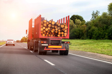 A semi-trailer truck transports logs from the forest to a wood products manufacturing plant. Forestry industry. Copy space for text