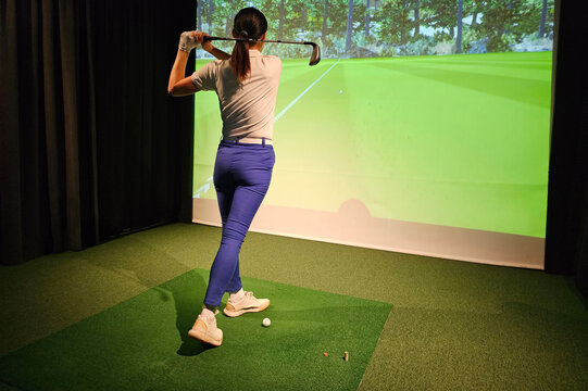 Golf swing practice at an indoor simulation facility with advanced technology and realistic graphics