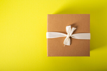 Box with a gift set of bath salts and handmade soap, close-up. Yellow background, copy space for text