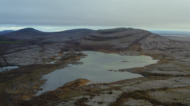 Aerial timelapse of Mullaghmore with seasonal lake and mountaineers in the Burren. Winter
