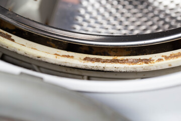 Obraz premium Dirt, mildew and mold in the hatch seals of the washing machine. Unsanitary and unpleasant smell. Cleaning and repairing stains in the washing machine, close-up