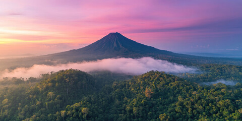 Fototapeta premium Aerial View of a Mountain Covered in Fog Under the Beams of Light for Atmospheric Landscape Photography