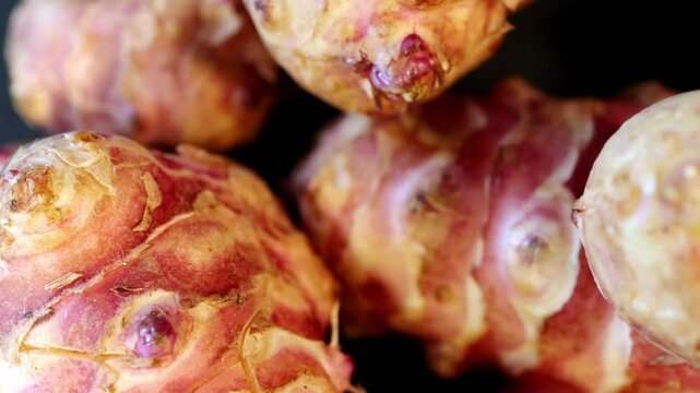 Unpeeled and raw Jerusalem artichokes or Topinambur on a table