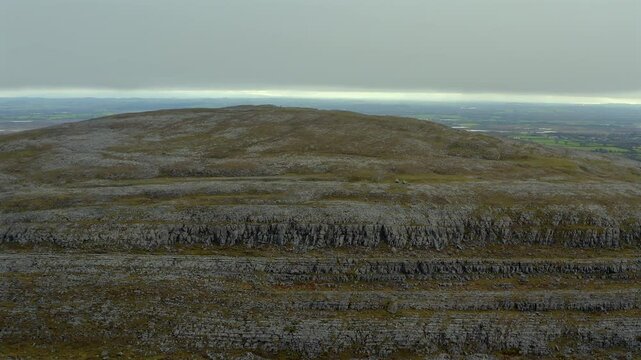 Circular aerial shot of Mullaghmore summit with mountaineers and stunning views. County Clare