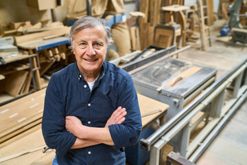 Experienced craftsman standing proudly in a busy lumberyard workshop