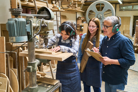 Teamwork in a lumberyard with apprentices and skilled mentor