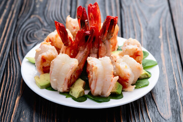 Salad with tiger shrimps , avocado and mango . Top view