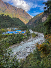 Cold water river between mountains and with blue houses in the valley

