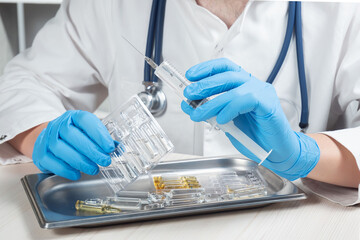 Fototapeta premium A young doctor in blue gloves checks the operation of a syringe. Close-up. Slow motion.