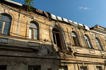 Fototapeta premium A building with a lot of windows and a balcony. The building is in a state of disrepair