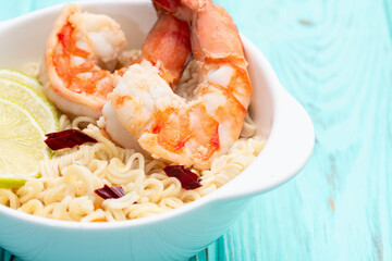 Tom yum soup with shrimps instant noodles and lime photography . Asian food . Top view