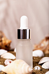 Frosted glass dropper bottle surrounded by seashells and sandy backdrop, portraying natural and luxurious skincare aesthetic. Ideal for promoting cosmetics or self-care products