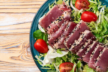 Salad with raw tuna , sesame and cherry tomatoes photography . Top view