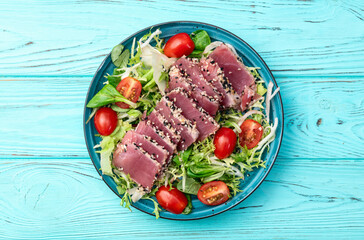 Salad with raw tuna , sesame and cherry tomatoes photography . Top view