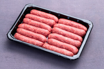 Raw beef sausages with rosemary and tomatoes photography . Top view