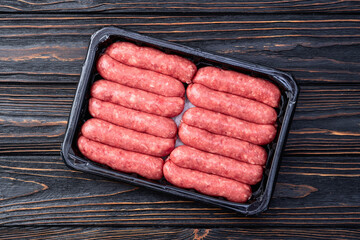 Raw beef sausages with rosemary and tomatoes photography . Top view