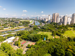 Obraz premium aerial view of Sao Paulo city in Brazil with a park, buildings, and Pinheiros river crossing the city. Marginal Pinheiros avenue with traffic during daylight