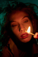 Vertical medium close up of woman completely concentrated on burning math while sitting in dimly...