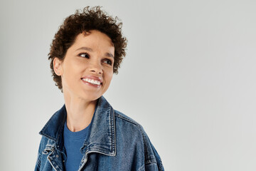 Expressive smile of a stylish young woman in casual denim attire enjoying a moment of joy