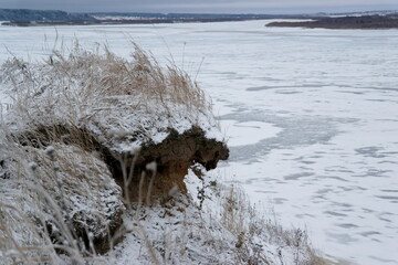frozen river and high bank in winter