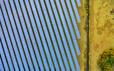 Aerial Drone View of a Solar Energy Farm in a Field.