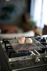 丸いお餅を網で焼いているところ