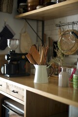 陶器のピッチャーにまとめた木製のキッチンツール