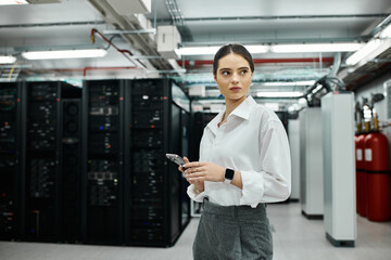 A skilled IT specialist in a white shirt oversees computer systems in a data center.