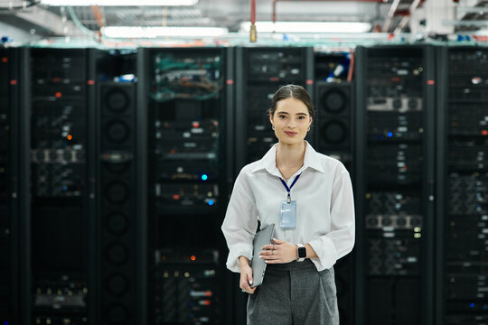 An IT specialist in a white shirt oversees operations in a sleek server room.