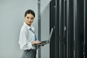A woman in a white shirt skillfully manages tasks in a modern server room filled with hardware.