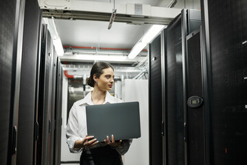 A skilled IT specialist works diligently in a modern server room, managing digital systems.