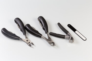 Professional stainless steel pedicure tools on a gray background