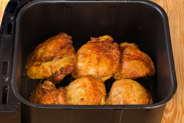 Freshly baked chicken thighs in the drawer of multi-oven