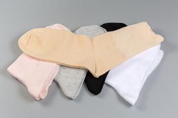Several pairs of the women's socks different colors on gray surface