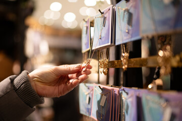 ネックレスを選ぶ女性の手