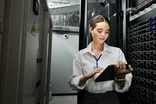 A skilled woman in a white shirt analyzes data in a bustling server room filled with technology.