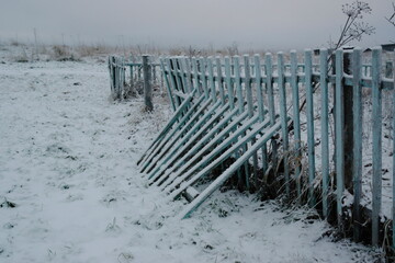 wooden fence in the snow on a plot in the countryside