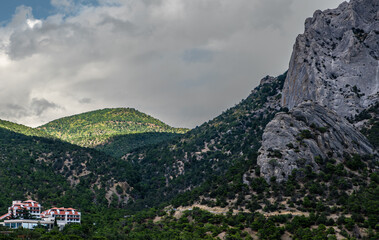 Mountains covered with forest against the sky on a summer day.