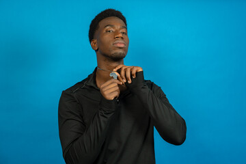 Young african american man showing africa continent pendant, symbol of pride and identity
